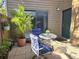 Cozy outdoor patio with stylish furniture, lush plants, and a sliding glass door entrance at 103 Cypress Pond Rd # 103, Palm Harbor, FL 34683