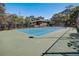 Outdoor tennis court surrounded by trees and fencing at 103 Cypress Pond Rd # 103, Palm Harbor, FL 34683