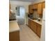 Bright kitchen with light wood cabinets and appliances at 8693 Bardmoor Blvd # 207B, Seminole, FL 33777