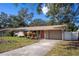 House exterior featuring a beige color scheme, a red door, and a driveway at 5288 62Nd N St, Kenneth City, FL 33709