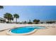 Community pool with surrounding lounge chairs and a grassy area at 235 Nautilus Way, Treasure Island, FL 33706