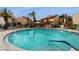 Round swimming pool surrounded by lounge chairs and palm trees at 2205 Belleair Rd # A13, Clearwater, FL 33764
