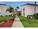 Pathway through a complex with light beige buildings and lush green landscaping at 2205 Belleair Rd # A13, Clearwater, FL 33764