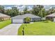 Charming single-story home featuring a well-manicured lawn, attached garage, and a welcoming front entrance at 1729 Oakwood Estates Dr, Plant City, FL 33563
