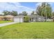 Ranch-style home with a green lawn and palm trees at 1729 Oakwood Estates Dr, Plant City, FL 33563