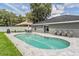 Inviting kidney-shaped pool with gray stone patio and seating at 1729 Oakwood Estates Dr, Plant City, FL 33563