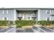 Gray two-story condo building with balconies and lush landscaping at 12125 Spartan Way # 201, Hudson, FL 34667