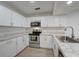 Modern kitchen with stainless steel appliances and white cabinets at 12125 Spartan Way # 201, Hudson, FL 34667