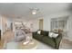 Spacious living room with a green couch and a view into the kitchen and dining area at 12125 Spartan Way # 201, Hudson, FL 34667
