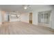 Open living room with wood-look floors, ceiling fan and laundry area at 12125 Spartan Way # 201, Hudson, FL 34667