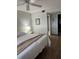 Cozy bedroom features wood-look flooring and a ceiling fan with an ensuite bathroom at 5157 Silent Loop # 302, New Port Richey, FL 34652