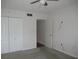 Carpeted bedroom with neutral walls, ceiling fan and a view of double closet at 940 Virginia St # 107, Dunedin, FL 34698
