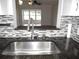 Modern kitchen features stainless steel sink, granite countertops, and stylish backsplash at 940 Virginia St # 107, Dunedin, FL 34698