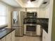 Modern kitchen with stainless steel appliances and granite countertop at 940 Virginia St # 107, Dunedin, FL 34698