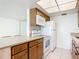 Modern kitchen with white appliances and light wood cabinets at 650 Pinellas Point S Dr # 128, St Petersburg, FL 33705