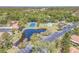 Aerial view of Timberwoods community, showcasing a serene pond, tennis court, pool, and ample parking at 9543 86Th Ave # 9543, Seminole, FL 33777