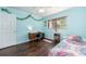 This bedroom features a ceiling fan, hardwood floors, and bright blue walls at 9543 86Th Ave # 9543, Seminole, FL 33777