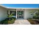 Elegant entryway with a modern black door and landscaping at 550 Johns Pass Ave, Madeira Beach, FL 33708