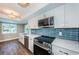 Updated kitchen, white cabinets, blue tile backsplash, stainless steel appliances at 550 Johns Pass Ave, Madeira Beach, FL 33708