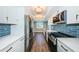 Modern kitchen with white cabinets, blue tile backsplash and stainless steel appliances at 550 Johns Pass Ave, Madeira Beach, FL 33708
