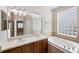 Bathroom with double vanity, soaking tub, and glass block window at 2622 Yukon Cliff Dr, Ruskin, FL 33570
