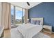 Cozy bedroom featuring stylish blue wallpaper, a comfortable bed, and a window with city views at 1000 Water St # 1703, Tampa, FL 33602