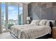 Bedroom featuring a textured accent wall, comfortable bed, and floor-to-ceiling windows with city views at 1000 Water St # 1703, Tampa, FL 33602