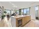 Modern kitchen with an island, wine cooler, and views into the living area and city skyline at 1000 Water St # 1703, Tampa, FL 33602