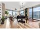 Spacious living room with a piano, comfortable seating, and floor-to-ceiling windows with city views at 1000 Water St # 1703, Tampa, FL 33602