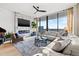 A modern living room featuring a fireplace, TV, comfortable sectional, and panoramic city views at 1000 Water St # 1703, Tampa, FL 33602