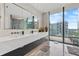 Double vanity bathroom with large mirror and city view at 1000 Water St # 1703, Tampa, FL 33602