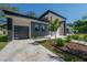 Contemporary home with gray and white exterior, landscaping, and a paved driveway at 4511 24Th S Ave, St Petersburg, FL 33711