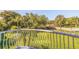 A serene balcony view showcasing lush greenery, palm trees, and a charming wooden bridge for this beautiful property at 6251 Vista Verde W Dr, St Petersburg, FL 33707