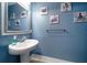 Small bathroom with pedestal sink, mirror, and beach-themed decor at 300 150Th Ave # 411, Madeira Beach, FL 33708