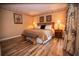 King-size bed in bright bedroom with wood-look floors and bench at 36750 Us 19 # 2052, Palm Harbor, FL 34684