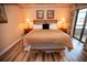 King-size bed in bright bedroom with wood-look floors and bench at 36750 Us 19 # 2052, Palm Harbor, FL 34684