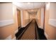 Long hallway with carpet, baseboards, and overhead lighting leading to rooms in a building at 36750 Us 19 # 2052, Palm Harbor, FL 34684
