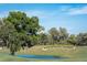 Beautifully landscaped community area with lush trees and a tranquil pond at 36750 Us 19 # 2052, Palm Harbor, FL 34684