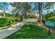 Lush green pool area with a gated entrance and signage for the Peacock Pool at 36750 Us 19 # 2052, Palm Harbor, FL 34684