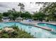 Large community pool with lounge chairs and lush greenery at 36750 Us 19 # 2052, Palm Harbor, FL 34684