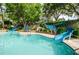 Community pool featuring water slides and lush landscaping at 36750 Us 19 # 2052, Palm Harbor, FL 34684