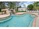 Community pool area with a waterfall feature and lounge chairs at 36750 Us 19 # 2052, Palm Harbor, FL 34684