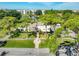 An aerial of the community clubhouse, lush trees, landscaping, sidewalks, and pond in the background at 8174 Terrace Garden N Dr # 207, St Petersburg, FL 33709