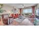 Bright living room with tiled floors, comfy seating, and sliding glass doors leading to a balcony at 7296 Marathon Dr # 504, Seminole, FL 33777