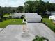 Aerial view of a home featuring a three-car garage, a long driveway, and landscaping and a well-manicured lawn at 3357 38Th S St # A, St Petersburg, FL 33711