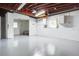Spacious basement featuring painted flooring and ceiling rafters, with an open doorway to another room at 3505 75Th N St, St Petersburg, FL 33710