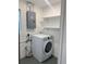 Laundry area featuring a modern white washing machine, shelving, and practical utility setup at 3505 75Th N St, St Petersburg, FL 33710