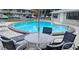 Community pool with patio furniture and umbrella at 101 Lake Ne Ave # 222, Largo, FL 33771