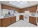 Bright kitchen with wood cabinets, white appliances, and tiled floor at 203 Mariner Dr # 203, Tarpon Springs, FL 34689