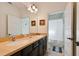 Bright bathroom featuring double sinks with dark cabinets and framed mirrors, and a tile shower at 395 Ulelah Ave, Palm Harbor, FL 34683